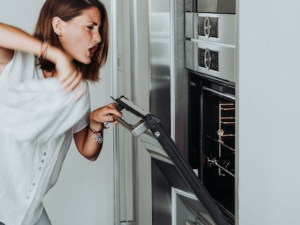 Blonde woman standing in a modern kitchen, representing a Perth homeowner experiencing unexplained power tripping or electrical issues.