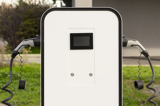 A modern, wall-mounted EV fast charger designed for electric or hybrid vehicles in a residential setting.